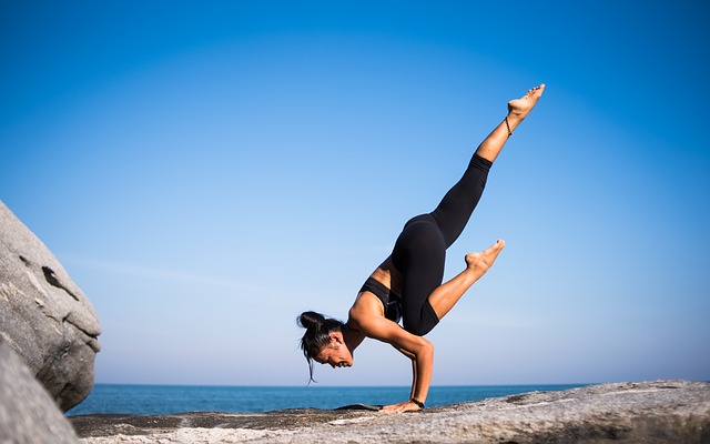 Image of Woman Balancing on Her Hands on a Cliff - CoffeyFit.com